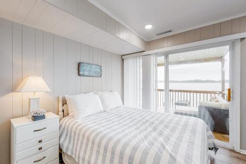 a white bedroom with a bed and a balcony at 14 Clipper on the Bay in Ocean Pines