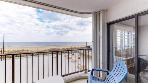 a balcony with a blue chair and a view of the beach at Plaza 211 in Ocean City