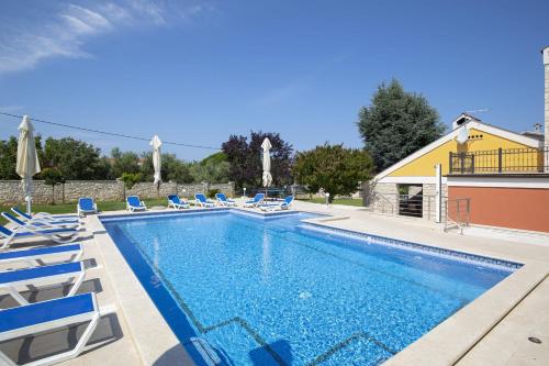 a swimming pool with lounge chairs and a swimming pool at Villa Suzanne in Banjole