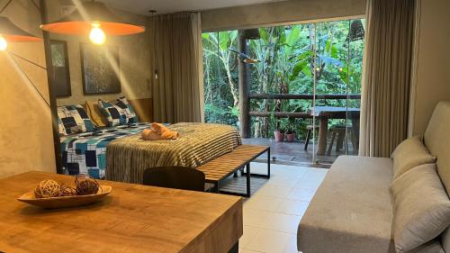 a bedroom with a bed and a table and a couch at Villas Pratagy Flor de Lis 901-Studio in Maceió