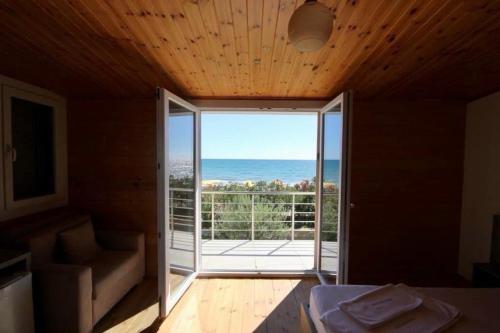 a room with a large glass door with a view of the ocean at Shengjin villa in Shëngjin