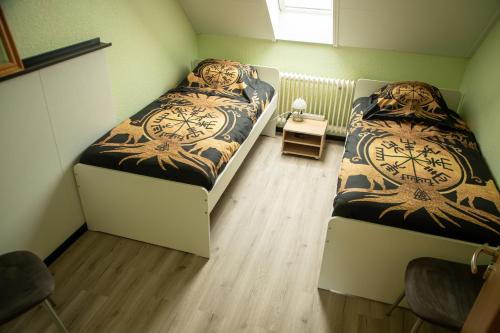 a bedroom with two beds with a clock on them at Narnia in Heede