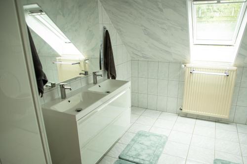 a white bathroom with a sink and a window at Narnia in Heede