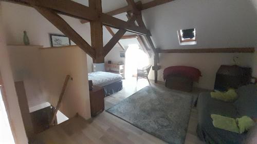 a room with a bedroom with a bed and a couch at Badger Cottage in Salagnac