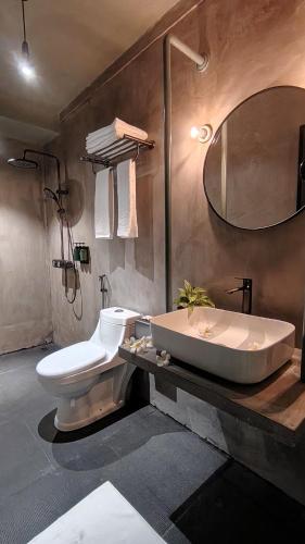 a bathroom with a sink and a toilet and a tub at Grids by Epic Collection in Unawatuna