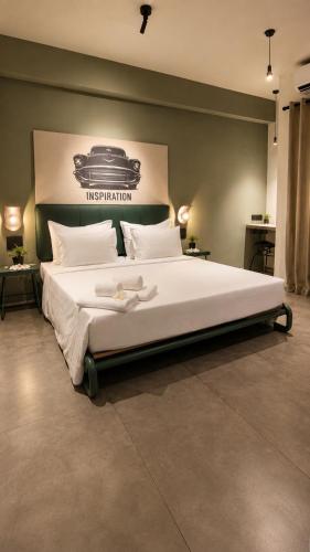 a large white bed in a room with a poster of a car at Grids by Epic Collection in Unawatuna