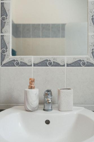 a bathroom sink with a roll of toilet paper and a mirror at Chloraka Sea View Apt with Pool in Khlorakas