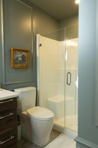 a bathroom with a toilet and a glass shower at The Point on Wood Lake in Lake Country