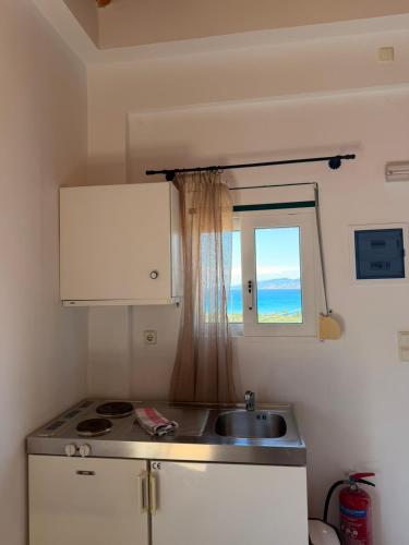 a small kitchen with a sink and a window at Sunset elafonisos in Elafonisos