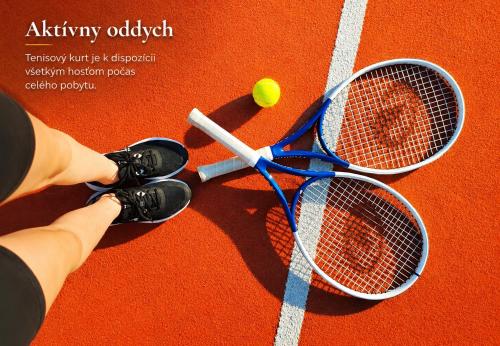 two tennis rackets and a ball on a tennis court at Penzion Kormoran in Námestovo