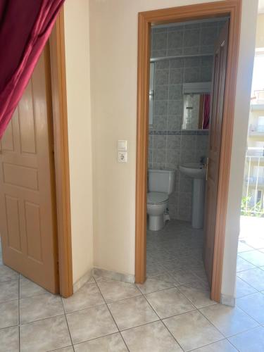 a bathroom with a toilet and a sink and a door at RRooms in Nafpaktos