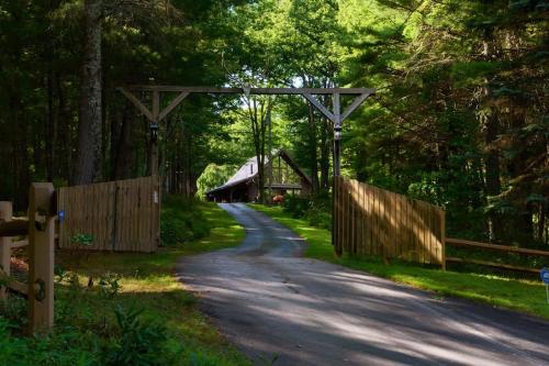 a country road with a barn and a wooden fence at The Luxury Cabin at Deep Hollow in Narrowsburg