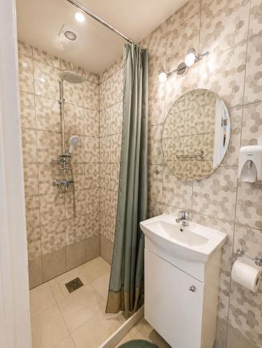 a bathroom with a sink and a shower at Arāja apartamenti in Kuldīga