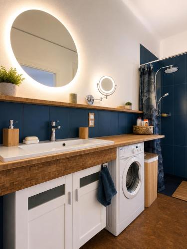 a bathroom with a sink and a washing machine at Esther's Studio Keszthely in Keszthely