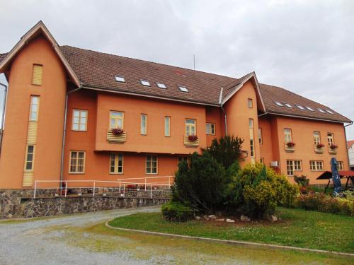 a large orange building with windows and plants at Pensiunea Praid - Parajd Panzió in Praid