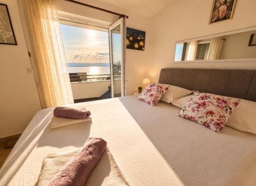 a bedroom with a large bed with a large window at Apartman Štorija with Private Jacuzzi-Brela in Brela