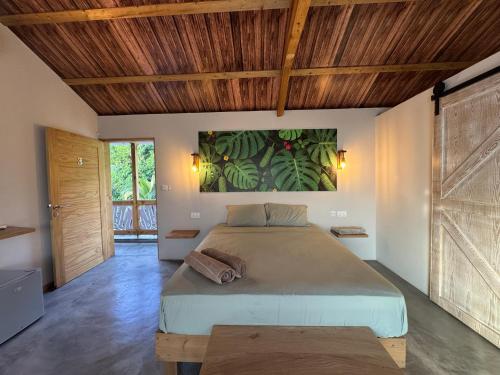 a bedroom with a large bed and a wooden ceiling at La Cabane D Eté in Port Mathurin