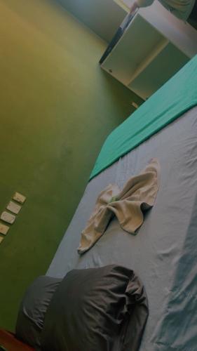 a bed in a room with a blanket on it at hotel larena in Sete Lagoas