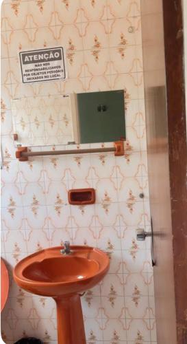 a bathroom with a sink and a sign on the wall at hotel larena in Sete Lagoas