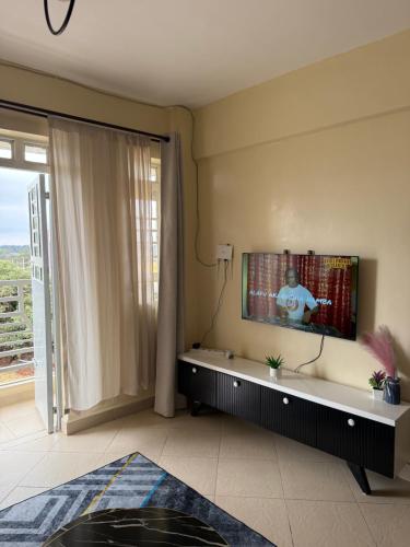 a living room with a flat screen tv on a wall at Luxe homes kenol in Kabuku