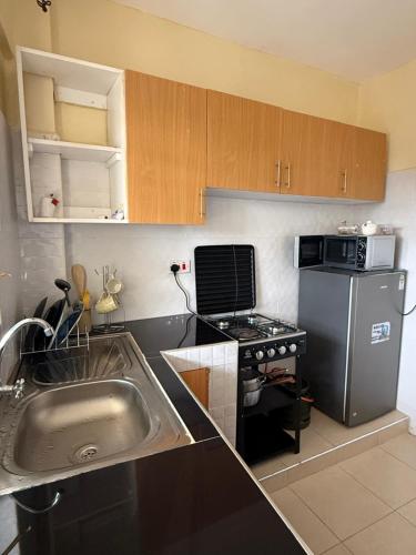 a small kitchen with a sink and a stove at Luxe homes kenol in Kabuku
