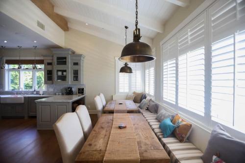 a living room with a wooden table and a kitchen at Playa Penthouse (Ocean Views) in Carpinteria