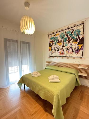 a bedroom with a green bed with a painting on the wall at La Fenice in Citta' Sant'Angelo