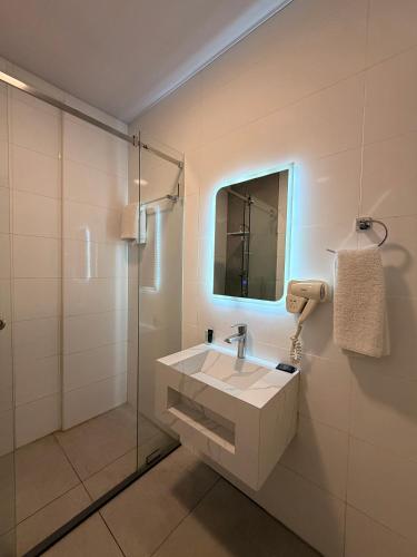 a white bathroom with a sink and a mirror at Regent Palace Hariz Hotel in Aley
