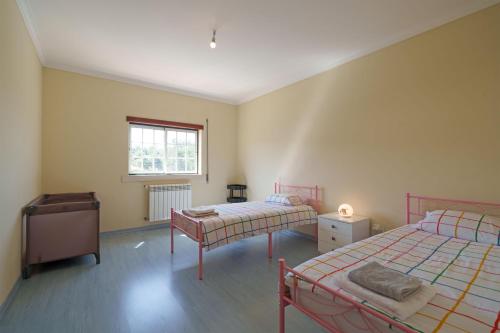 a bedroom with two beds and a window at Família de Arega in Arega