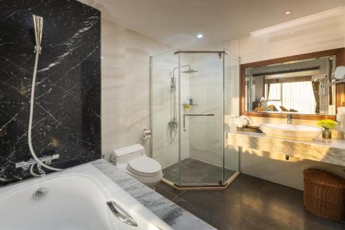 a bathroom with a tub and a toilet and a sink at Cat Ba Paradise Hotel - Sirocco Sky Bar & Massage in Cat Ba
