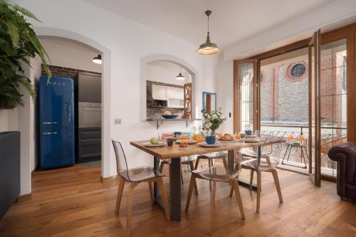 a kitchen and dining room with a wooden table and chairs at Appartamento Nel Sole in Passignano sul Trasimeno