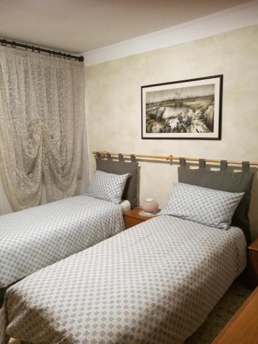 zwei Betten, die in einem Zimmer nebeneinander stehen in der Unterkunft Alberta in Bertiolo