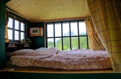 a bedroom with a bed and a window at Strackxhoeve Tiny House 'Knalselder' in Laakdal