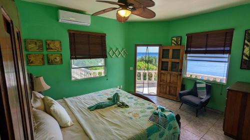 a bedroom with green walls and a bed with a toy on it at El Palacio Rosa, The Palace in Punta Gorda