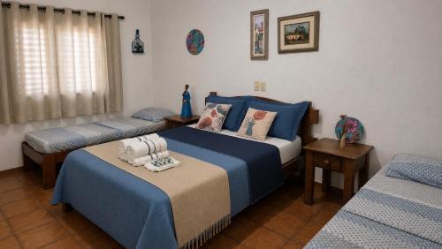 a bedroom with two beds with blue sheets at POUSADA SERRA DA CANASTRA in Delfinópolis