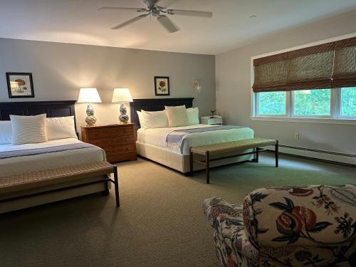 a bedroom with two beds and a couch at OneSixtyFive, The Inn on Park Row in Brunswick