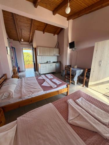 a large room with two beds and a television at Ilios Kalamaki in Kalamaki