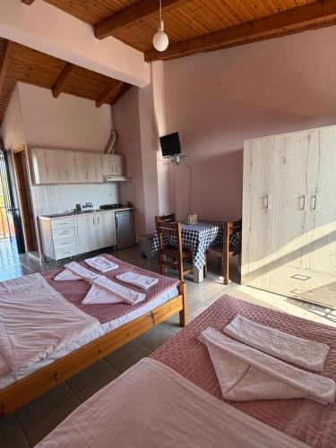 a room with two beds and a table and a kitchen at Ilios Kalamaki in Kalamaki