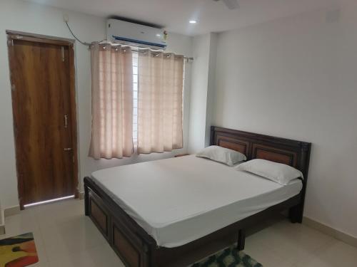a bedroom with a bed in a room with a window at Purabi homestay in Silchar