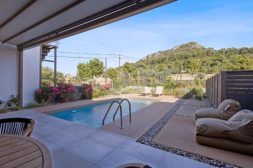 a house with a swimming pool with a mountain in the background at Saronia Estate in Galatákion
