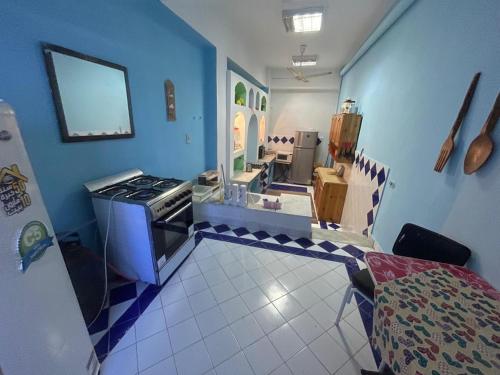 a kitchen with a stove and a blue wall at EL Fouly Villa beach front -North Coast فيلا لمة العيله الفولي - سيدي كرير - الساحل الشمالي in Abû Zeira