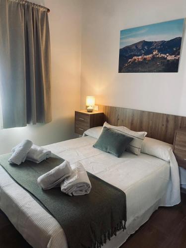 a bedroom with a bed with two towels on it at Casa El saucar in El Robledo