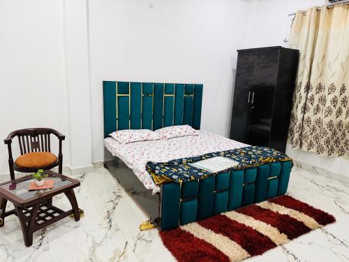 a bedroom with a bed and a chair and a table at Sadhana kunj in Varanasi