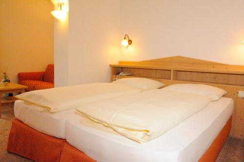 a bedroom with a large white bed in a room at Hotel Diana in Seefeld in Tirol