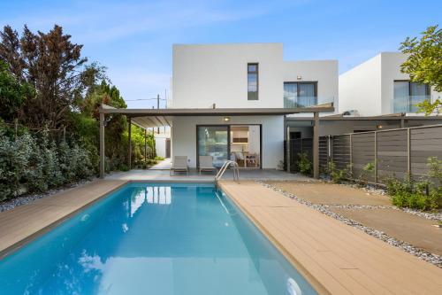 a house with a swimming pool in front of it at Saronia Estate in Galatákion