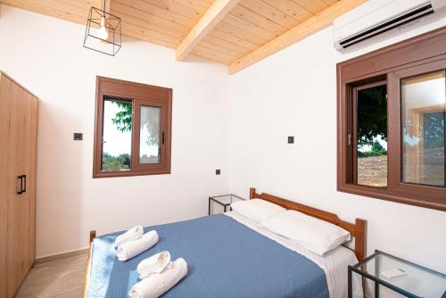 a bedroom with a blue bed and two windows at Mulberry Tree House in Póndi