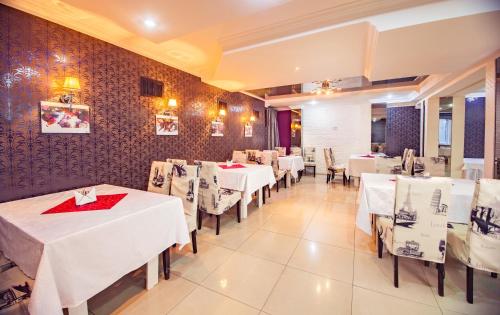 a dining room with white tables and chairs at Europa Hotel in Chişinău