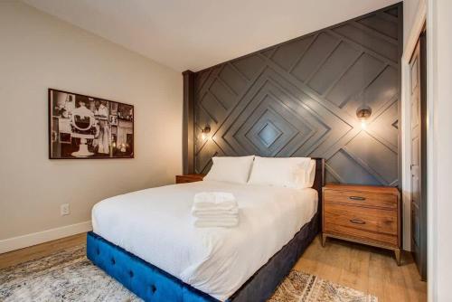 a bedroom with a large bed with a wooden headboard at Modern ADA-Accessible Studio - Tennyson St Escape in Denver