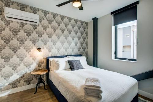 a bedroom with a bed and a wall at Walkable Urban Tennyson St Apt - Steps to Eats in Denver