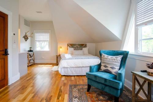 a bedroom with a bed and a blue chair at Pinky's Palace - Curtis Park Club - RiNo in Denver